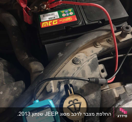 בודק סוללה מחובר למצבר רכב עם כבלים אדומים